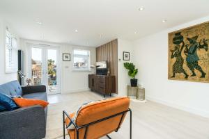 a living room with a couch and a chair at Spacious Modern 2 Bedroom London Flat in Sydenham