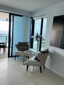sala de estar con sillas y mesa con vistas al océano en Soul Luxury Apartment’s, en Gold Coast