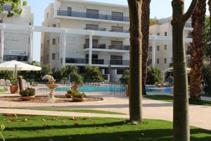a resort with a swimming pool and a building at Kings suite at Royal Park Eilat in Eilat