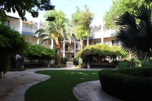 a building with palm trees and a walk way at Kings suite at Royal Park Eilat in Eilat