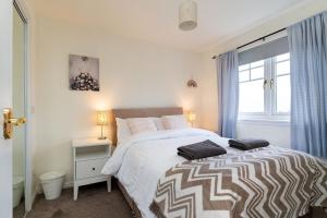 a bedroom with a large bed and a window at 4 Bedroom Townhouse in Stirling in Stirling
