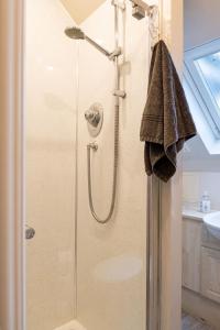 a shower with a glass door in a bathroom at 4 Bedroom Townhouse in Stirling in Stirling