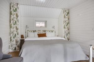 a bedroom with a white bed in a room at Smålandstorpet in Hok