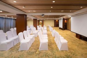 a conference room with white chairs and a screen at The Yun Resort QingYuan in Qingyuan
