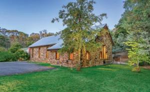 a stone house with a tree in the yard at DAYLESFORD Frog Hollow Estate THE BARN - Wanting a different experience - Stay in the Barn - Table Tennis Table - Cinema Projector - Bar - Wood Fireplace - 3 QUEEN BEDS - A fun place for everyone in Daylesford