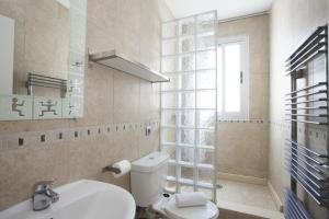 baño con aseo y lavabo y ventana en Carmen Apartments, en Valencia