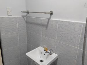 a bathroom with a white sink and a shower at JLF Inn in Daraga