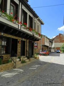 a street with a building with flower boxes on it at Guesthouse Koliovata Kashta in Gabrovo