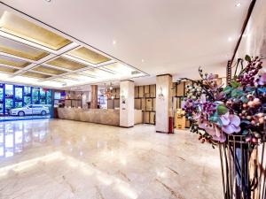 a lobby with flowers in a vase at Guangzhou Huihe Hotel in Guangzhou