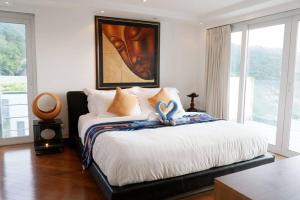 Schlafzimmer mit einem Bett mit Wandgemälde in der Unterkunft Kata Ocean View Condominium, Seaview & Luxury K12 in Ban Kata