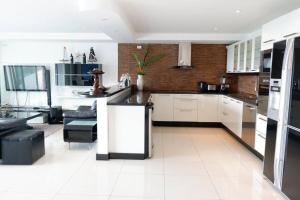 uma cozinha com armários brancos e um balcão preto em Kata Ocean View Condominium, Seaview & Luxury K12 em Ban Kata