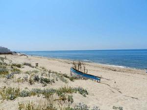 a blue boat sitting on a beach next to the ocean at DADA CAÑOS in Los Caños de Meca