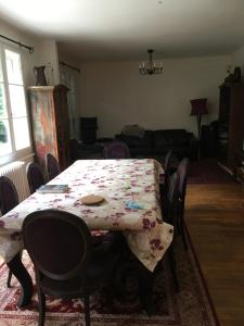 a dining room table with a floral table cloth on it at Villa Gif Sur Yvette centre - Paris Olympic game 2024 visitors in Gif-sur-Yvette