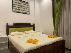 a bedroom with a bed with yellow bows on it at Private and Unique Stay At Angkor Siem Reap in Phumĭ Réach Born (2)