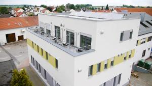 an aerial view of a white building with yellow windows at Hotel Fränkischer Hof in Ingolstadt