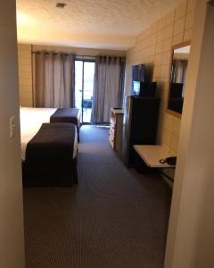 Habitación de hotel con 2 camas y TV en Airport Inn en Port Hardy