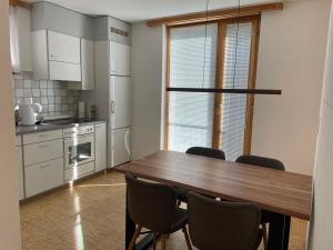 eine Küche mit einem Holztisch und Stühlen in der Unterkunft 2 Zimmer Wohnung in Lenzerheide