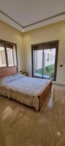 ein Schlafzimmer mit einem großen Bett und einem großen Fenster in der Unterkunft Résidence estrella in Bouznika