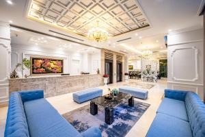 ein Wohnzimmer mit einem blauen Sofa und einem Tisch in der Unterkunft Acnos Grand Hotel in Ho-Chi-Minh-Stadt