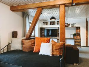a living room with a couch with pillows at Dorfplatz Loft - großzügig & modern nur 10Min von Rothenburg odT in Schrozberg