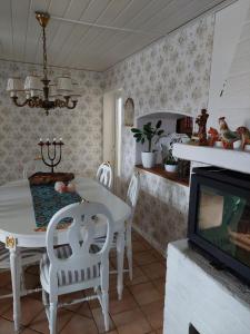 a dining room with a white table and chairs and a tv at Guest room in Uppsala