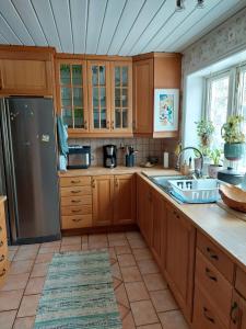a kitchen with wooden cabinets and a stainless steel refrigerator at Guest room in Uppsala