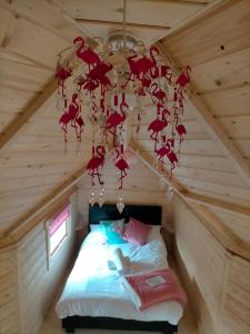 a room with a bed in a log cabin with a chandelier at Oak Tree Escape in Brome