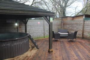 a patio with a hot tub and a table and chairs at Oak Tree Escape in Brome