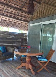 a wooden table and chairs on a deck at Brahmanhut - Eco Hut experience in harmony with nature, wellbeing and spirit in Bain Boeuf