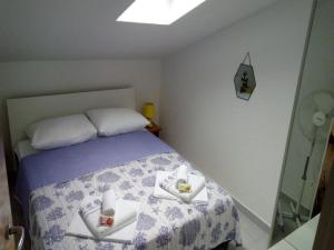 ein kleines Schlafzimmer mit einem Bett mit Handtüchern darauf in der Unterkunft Apartman Sutalo in Komarna