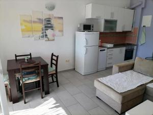 eine Küche und ein Wohnzimmer mit einem Sofa und einem Tisch in der Unterkunft Apartman Sutalo in Komarna