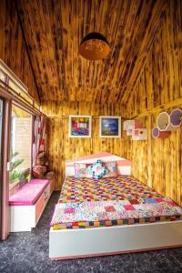 - une chambre avec un lit et un mur en bois dans l'établissement Roses Villa Tam Dao - Venuestay, à Tam Ðảo