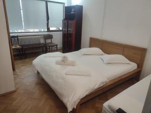 a bedroom with a bed with two towels on it at Iancu Apartments in Bucharest
