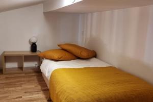 um quarto com uma cama com duas almofadas em T2 Charmant - Hypercentre - Quai de Garonne - Wifi em Toulouse