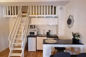 uma pequena cozinha com uma cama alta num pequeno apartamento em T2 Charmant - Hypercentre - Quai de Garonne - Wifi em Toulouse