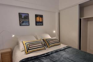 um quarto com uma cama com duas almofadas em T2 Charmant - Hypercentre - Quai de Garonne - Wifi em Toulouse