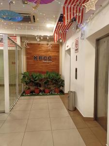 a lobby with a ktec sign on the wall and plants at Express Room KBCC in Kota Bharu
