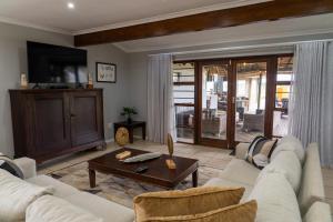 uma sala de estar com um sofá e uma mesa em Longhill Lodge em Addo