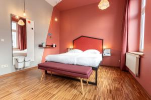 a bedroom with a large bed and a red wall at The Circus Hostel in Berlin