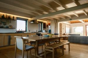 een keuken en eetkamer met een houten tafel en stoelen bij Landelijk Huisje te Houtem in Veurne