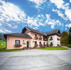 duży biały budynek z kwiatami przed nim w obiekcie Landhotel Lacknerhof w mieście Mariapfarr