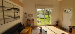 a living room with a couch and a large window at le clos des chevaliers in Pons