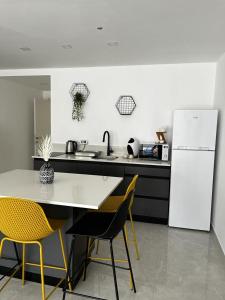 a kitchen with a white refrigerator and a table and chairs at מישל נופש ,צופית תחתית 6003 in Eilat