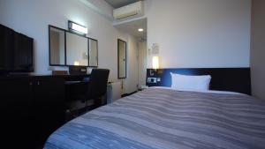 1 dormitorio con cama, escritorio y ordenador en Hotel Route-Inn Nagahama Inter en Nagahama