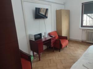 a room with a desk with a tv and a chair at Iancu Apartments in Bucharest