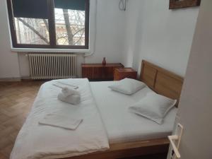a bedroom with two beds with white sheets and a window at Iancu Apartments in Bucharest