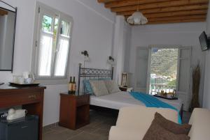 a bedroom with a bed and a couch and a window at Myrto Hotel in Kamares