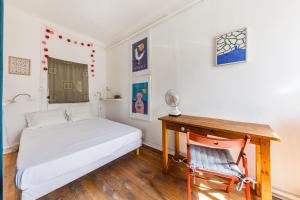 um quarto com uma cama, uma secretária e uma cadeira em Borsalino em Marselha