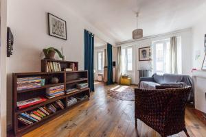 uma sala de estar com um sofá e uma estante de livros com livros em Borsalino em Marselha