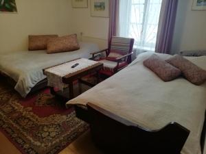 a room with two beds and a table and a chair at Poilsio kambariai Salake in Salakas
